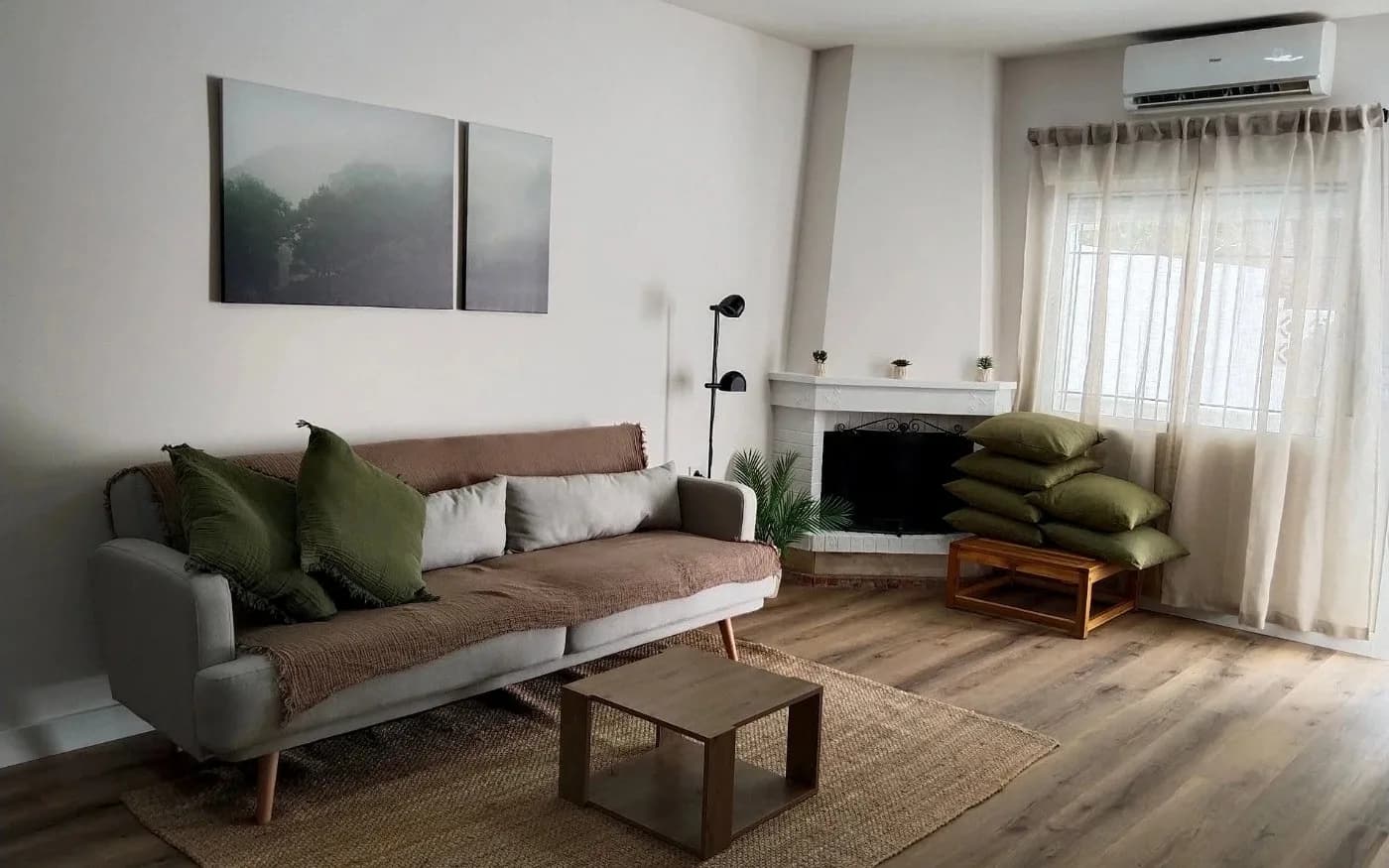 Completed living room with freshly painted white walls and wood-effect flooring.