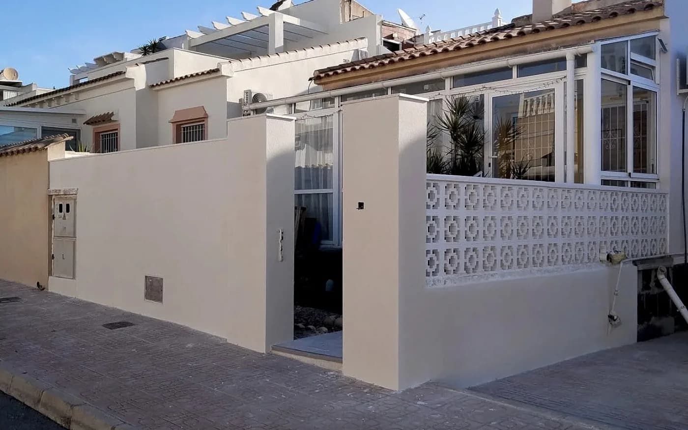 Completed exterior wall restoration and painting, showing the front boundary wall, entrance pillars and decorative blockwork.
