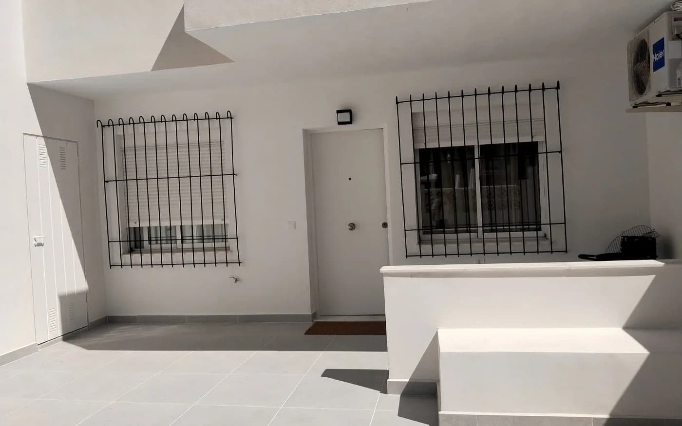 Completed front terrace with grey floor tiles and freshly painted white walls.